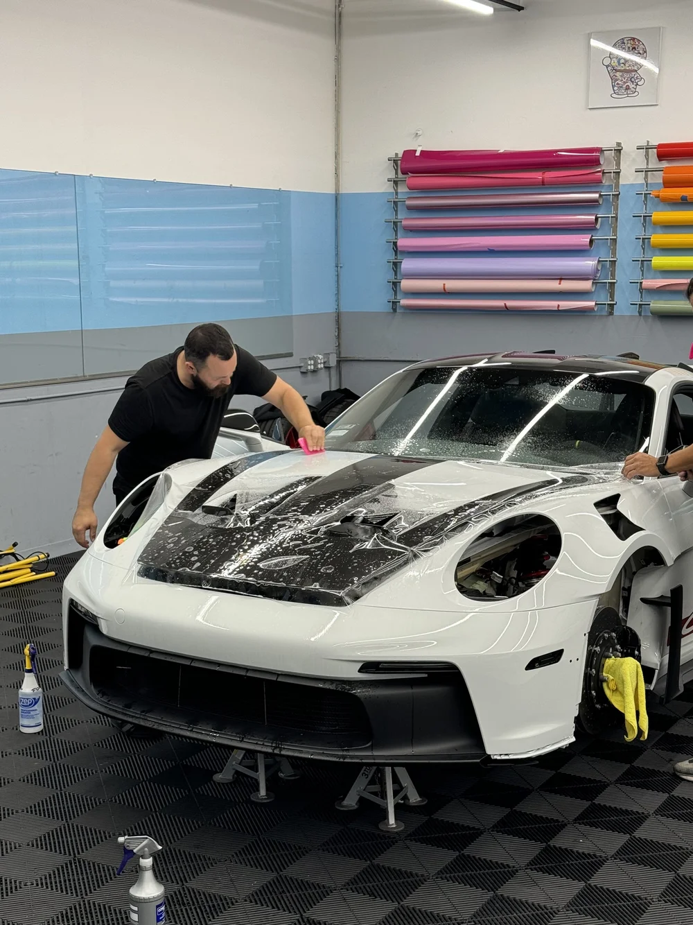 Technicians preparing a white Porsche for paint protection film at Toyz Detail Studio