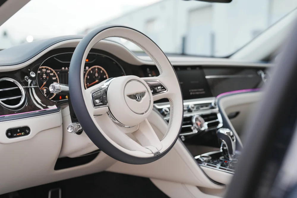 Cream-colored steering wheel and black dashboard above the center console.