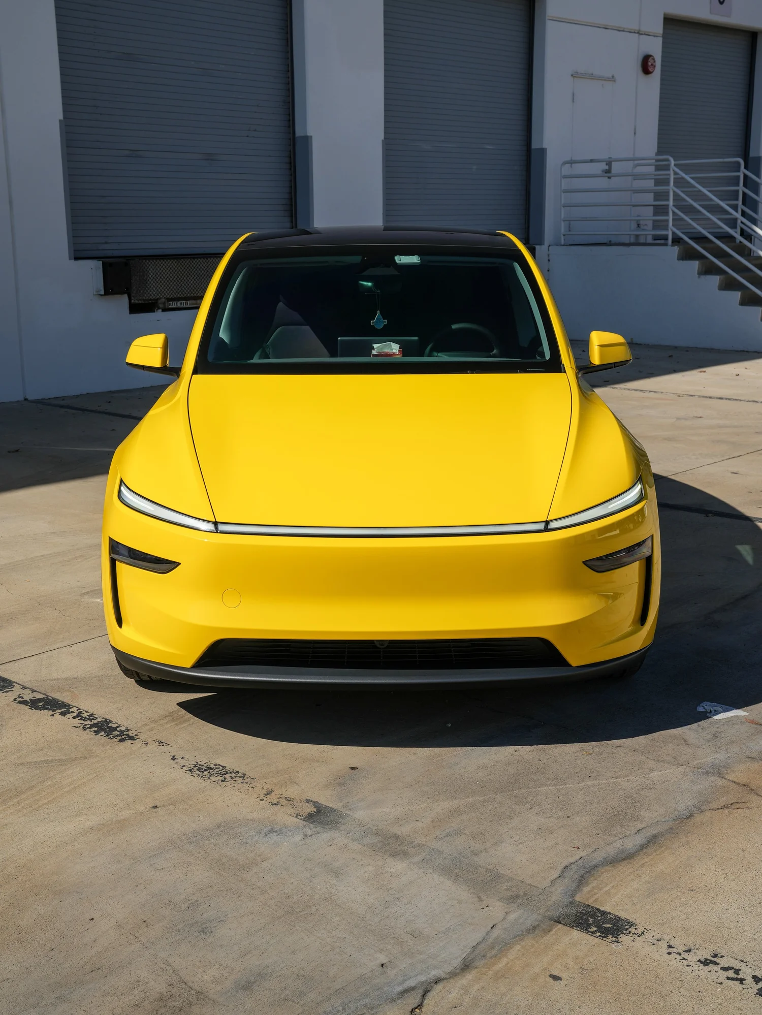 Tesla Model Y with Vegas Yellow vinyl wrap, direct front view