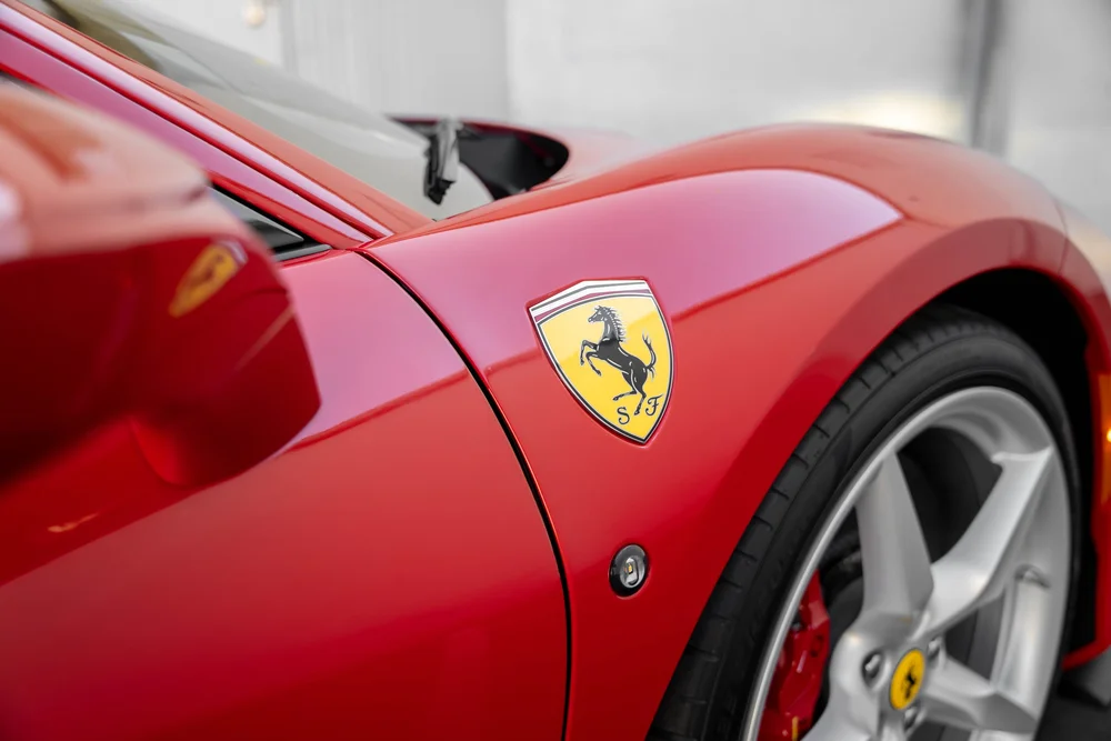 Ferrari shield on the red F8 front fender beside the silver wheel and side mirror