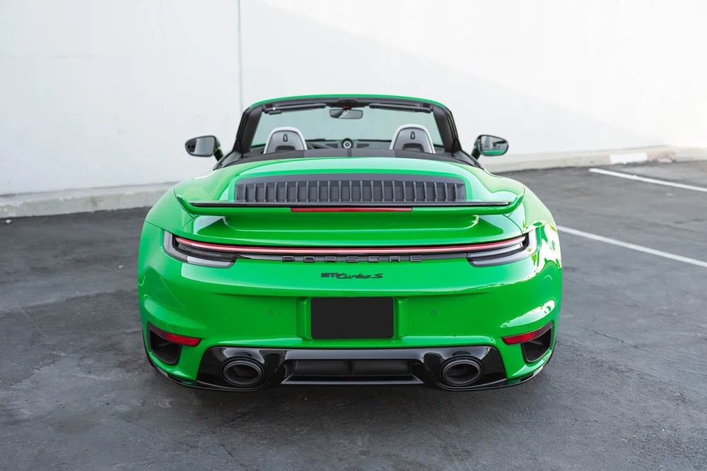 Signal Green Porsche 911 Turbo S, complete straight-rear view with raised spoiler, light bar and oval exhaust outlets