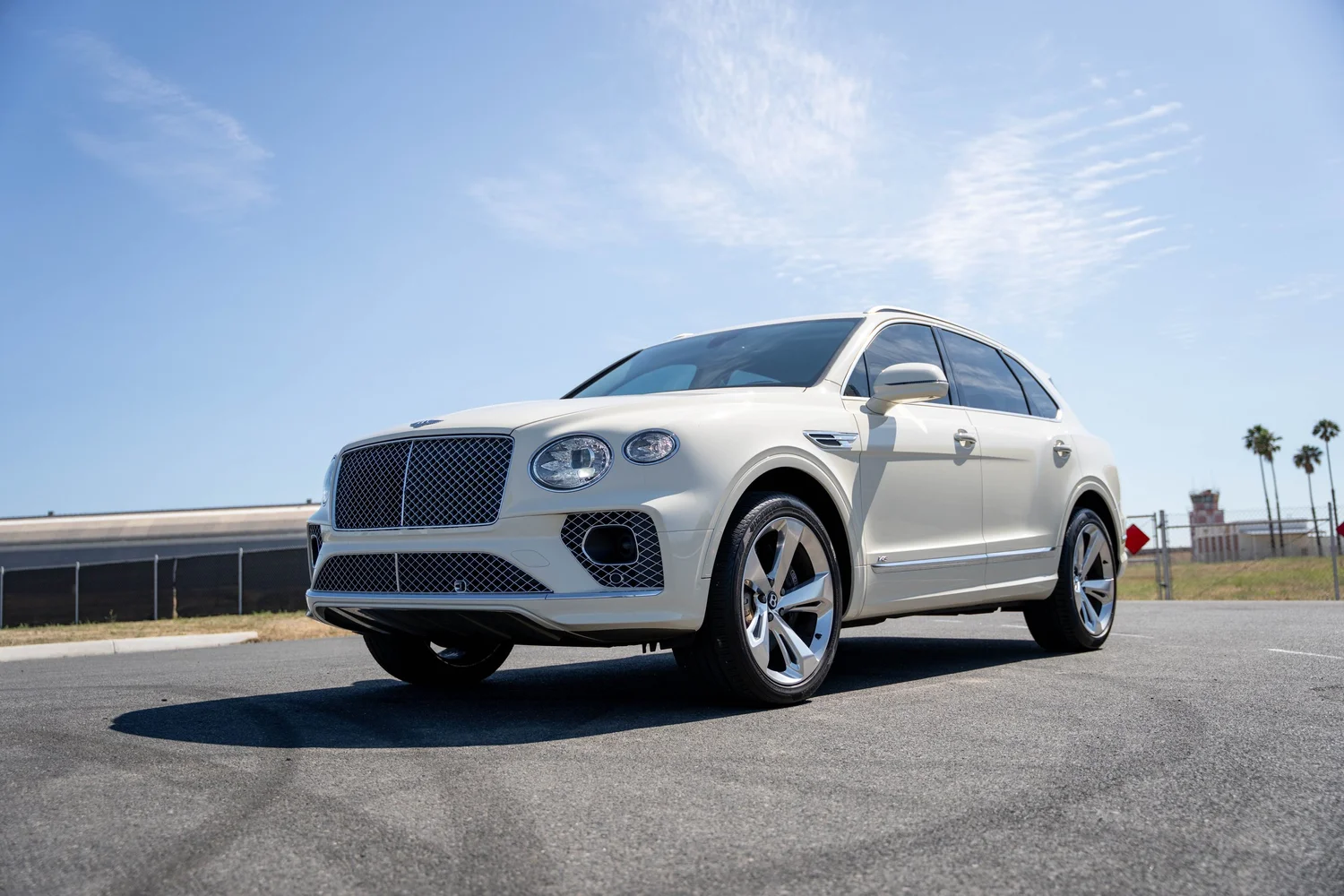 Low front three-quarter view of the white SUV from the opposite side.