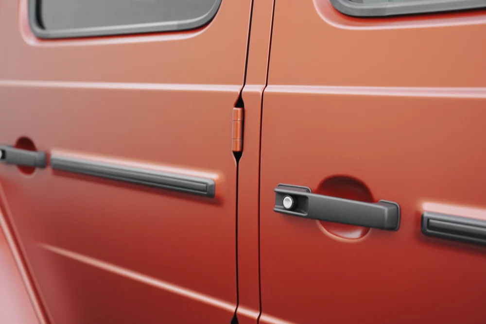 Matte red G63 door panels with black handles and body trim on either side of an external hinge