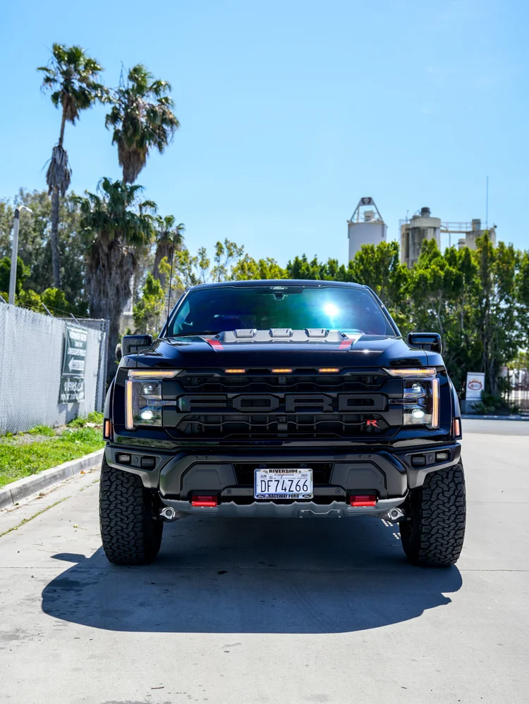 Straight front view of the Ford F-150 Raptor R with amber grille lights and red tow hooks.
