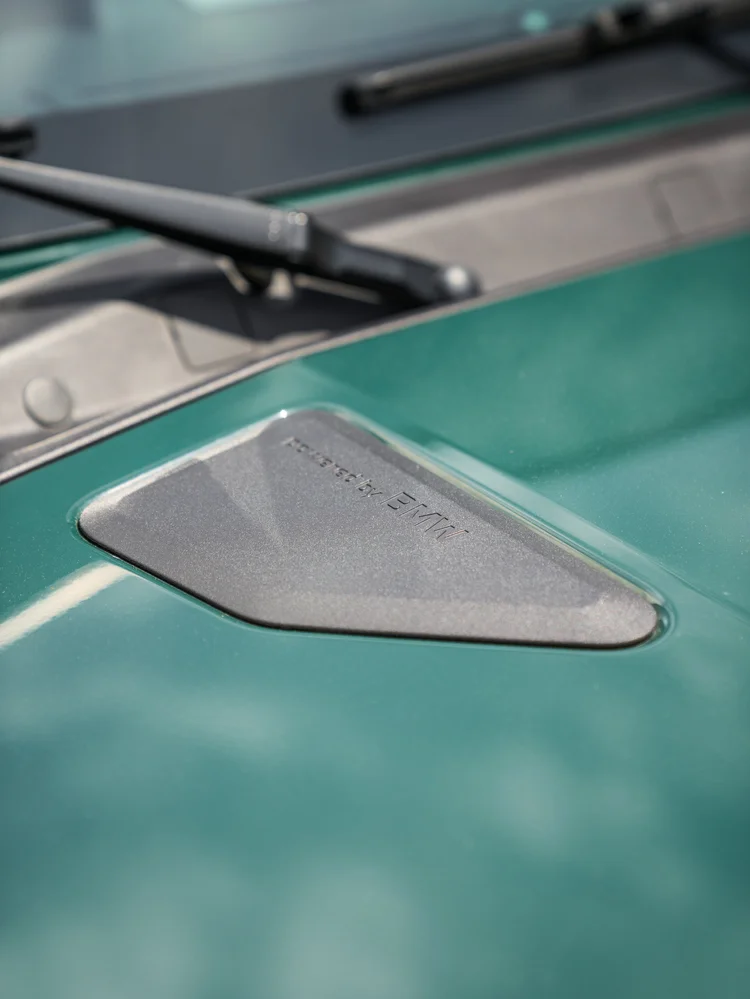 Close-up of the triangular hood trim and windshield-wiper base on the green INEOS Grenadier.