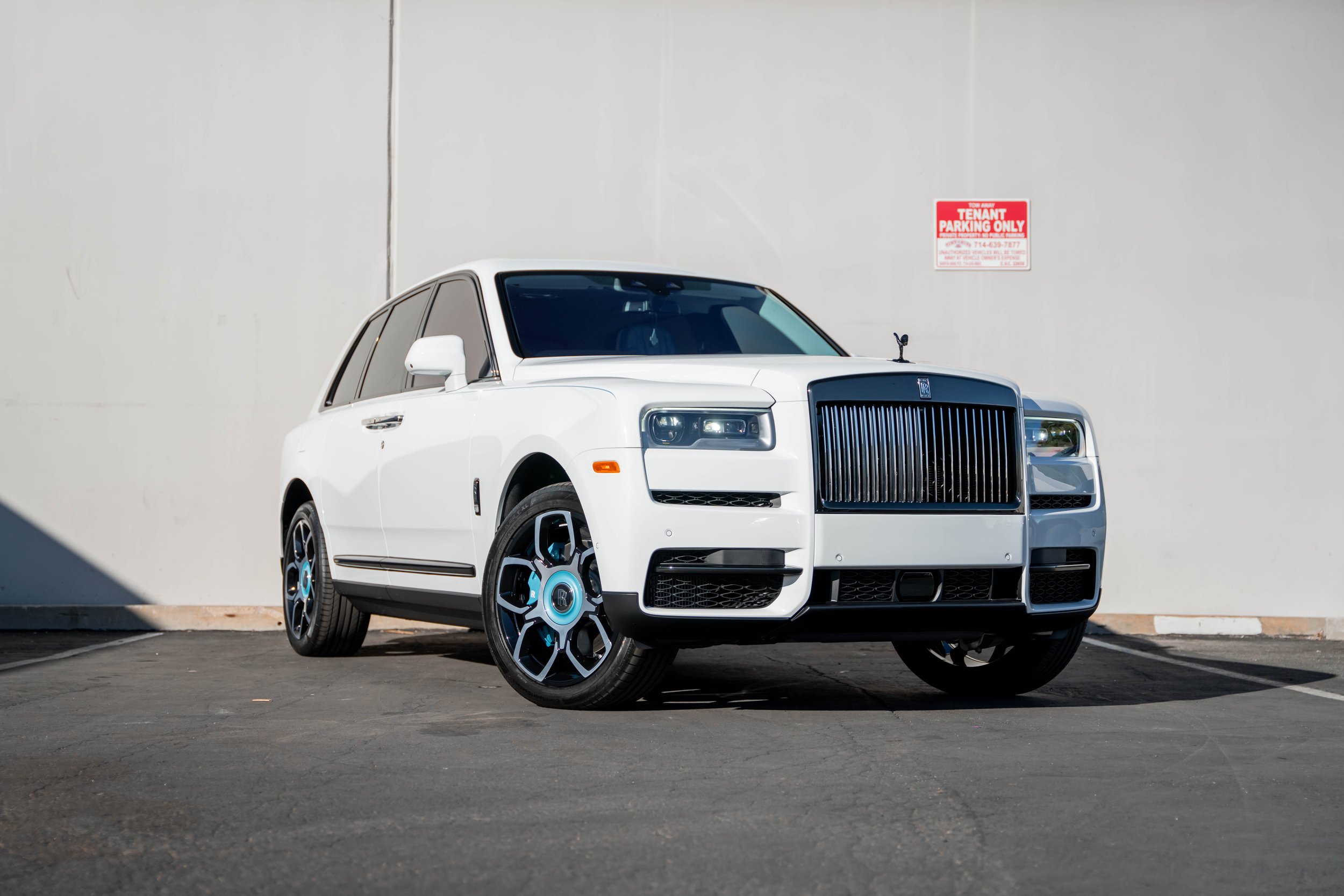 White Rolls-Royce Cullinan — complete front three-quarter view showing the upright grille and turquoise wheel accents