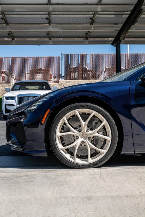 Low opposite-side view of the W16 Mistral front wheel, blue fender, headlight and front lip