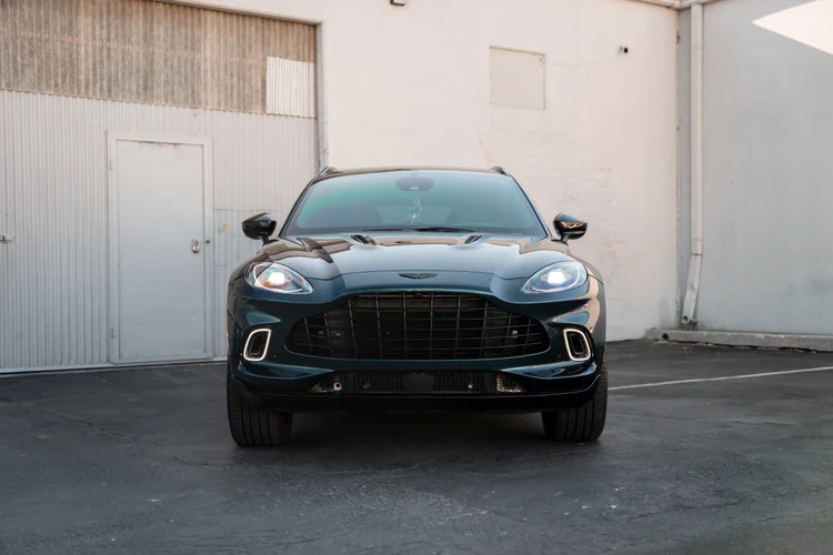 Complete front view of the green SUV with its wide black grille.
