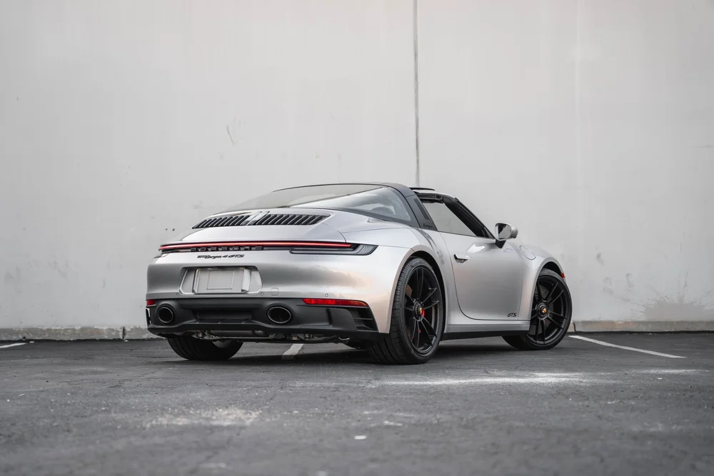 Full rear three-quarter view of the silver Targa 4 GTS with black wheels and open roof