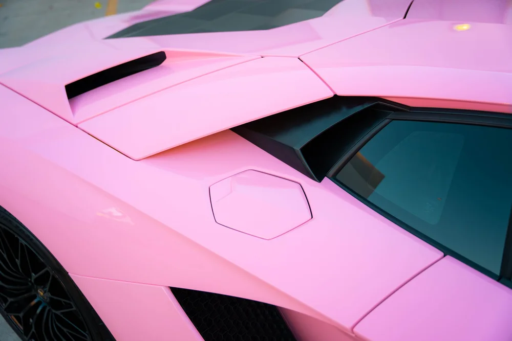 Elevated view of the Aventador angular Sakura Pink rear-quarter panels beside the black side intake and deck louvers