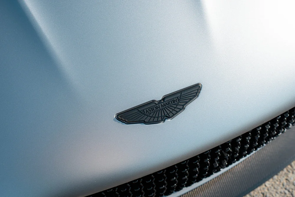Aston Martin wing badge on the matte DBS hood above the dark front grille