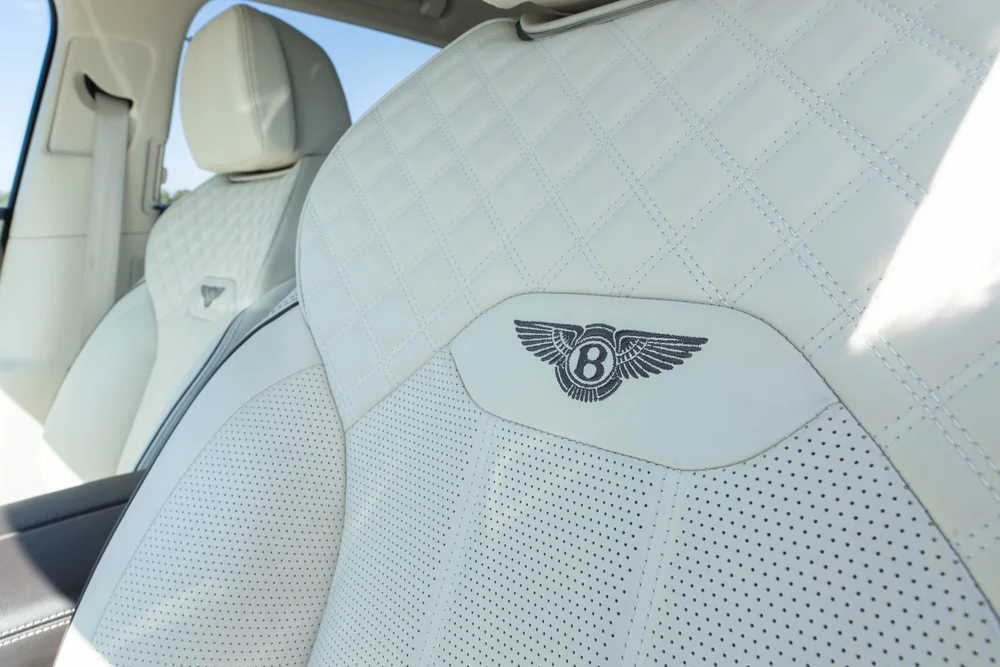 Quilted cream-colored seat with a winged Bentley emblem on the backrest.