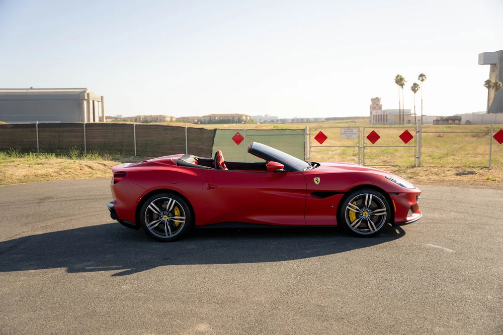 Red Ferrari Portofino in full side profile with lowered roof, two-tone wheels and yellow brake calipers