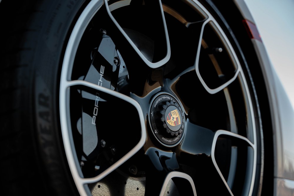 Chalk Porsche 911 Turbo S, wheel close-up with black spokes, bright edges and Porsche crest