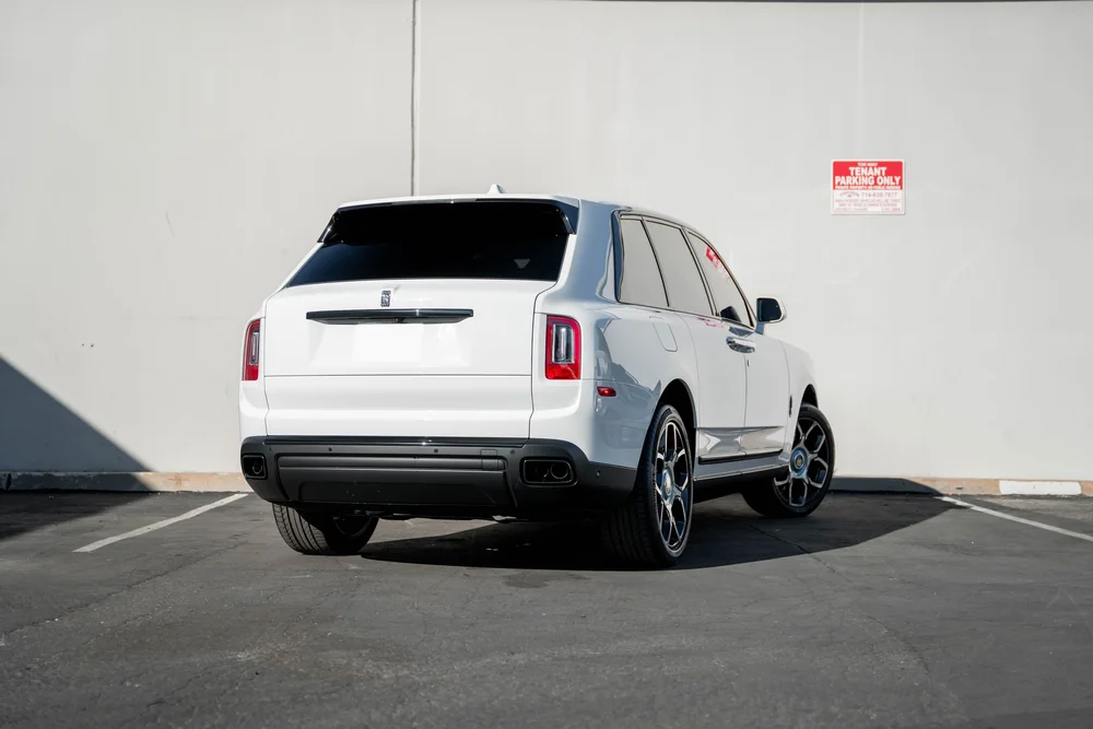 White Rolls-Royce Cullinan — complete rear three-quarter view with open pavement around the SUV