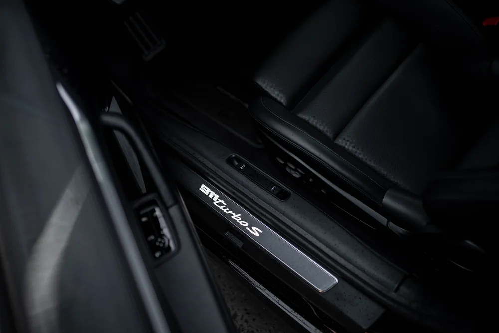 Porsche 911 Turbo S door-sill badge beside the black seat