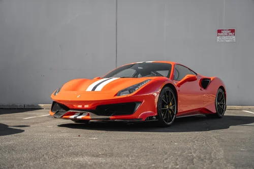 Ferrari 488 Pista in a low front three-quarter view, showing its central stripe, black wheels and side intake