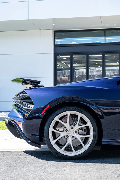 Bugatti W16 Mistral silver rear wheel beneath the Atlantic Blue fender, with the raised rear wing above