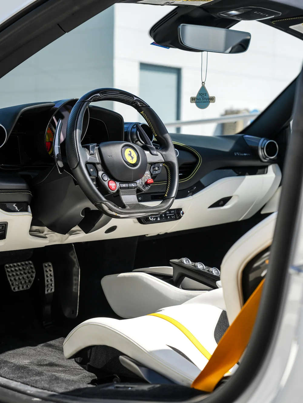 Ferrari F8 Spider cockpit showing the steering wheel, dashboard and front seat