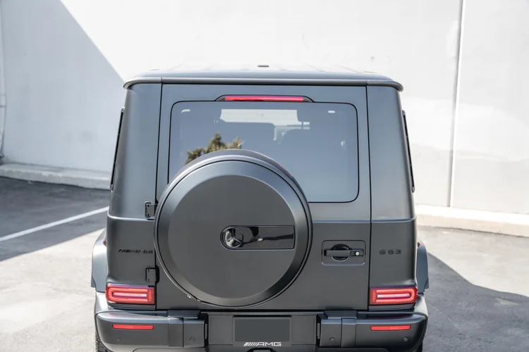 Tightly framed rear of the grey G 63 with both red lamps and the spare-wheel cover, with the lower bumper and tires outside the frame
