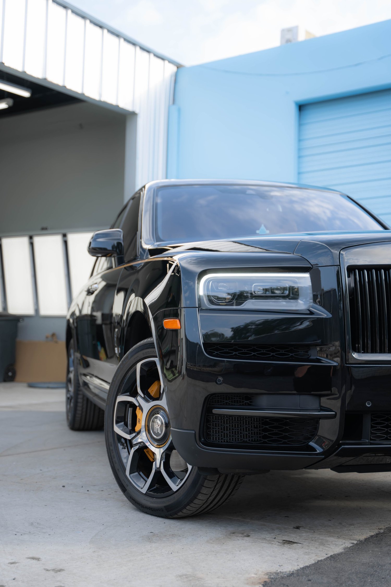 Black Rolls-Royce Cullinan Black Badge with Yellow Brake Calipers after Paint Protection Film (PPF), Window Tint and Ceramic Coating, front-fender and wheel view
