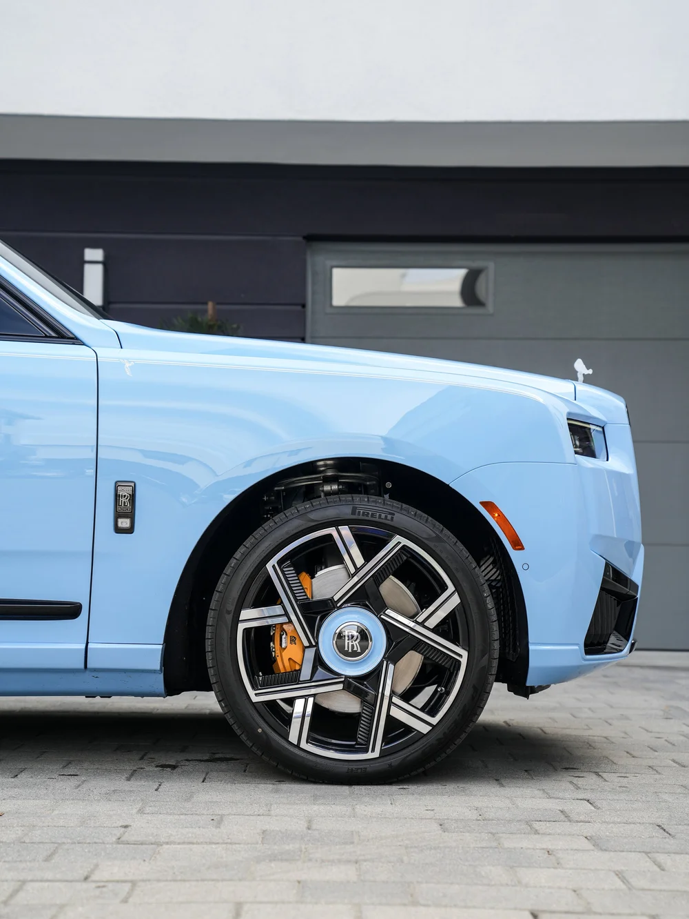 Powder Blue Cullinan front fender and two-tone wheel with the factory gold brake caliper visible behind the spokes