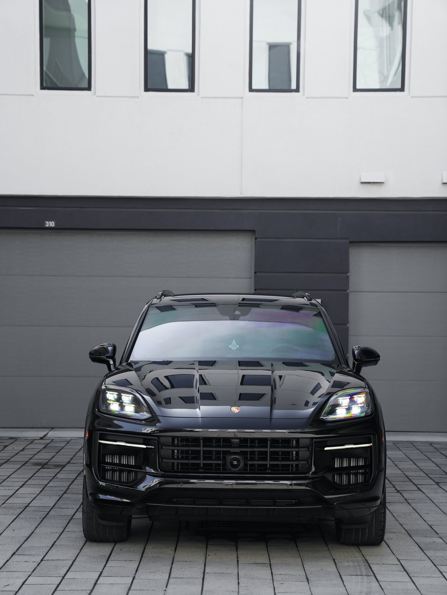Black Porsche Cayenne GTS after Paint Protection Film (PPF), Window Tint and Ceramic Coating, low-angle front view