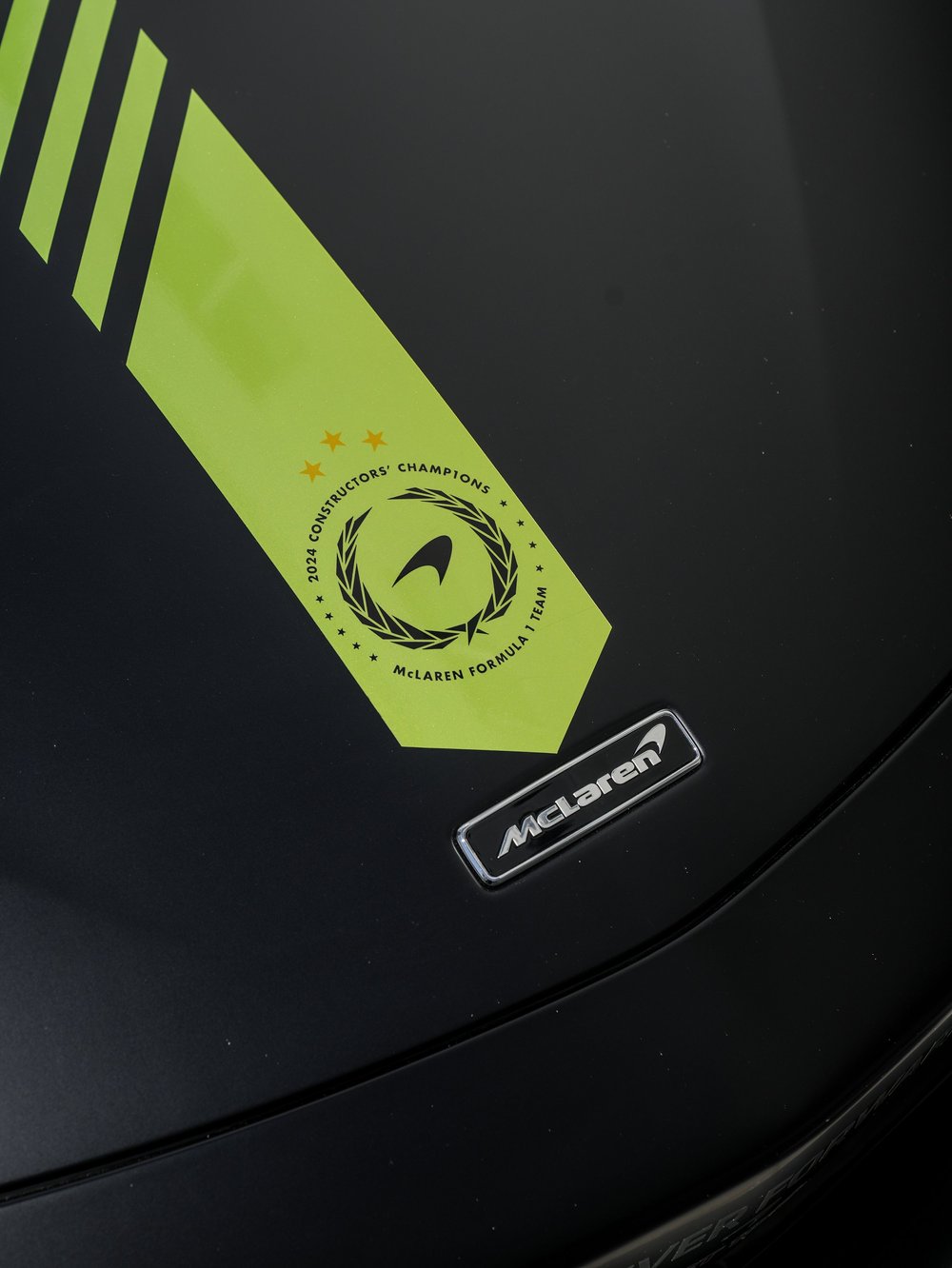 Green hood stripe and circular championship graphic on the dark Artura hood