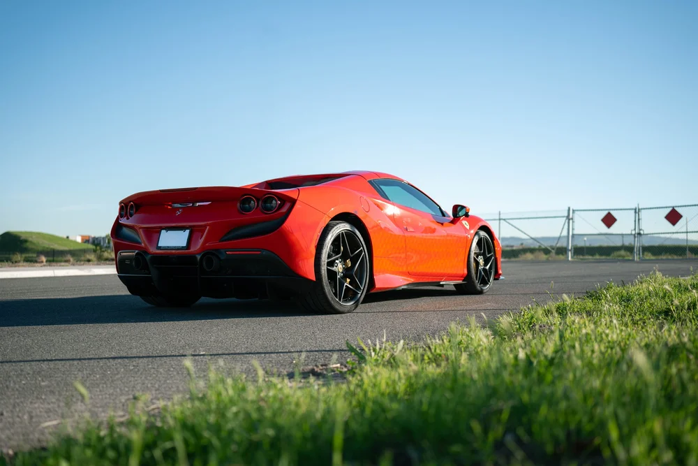 Low rear three-quarter view of the complete red Ferrari F8 with black wheels