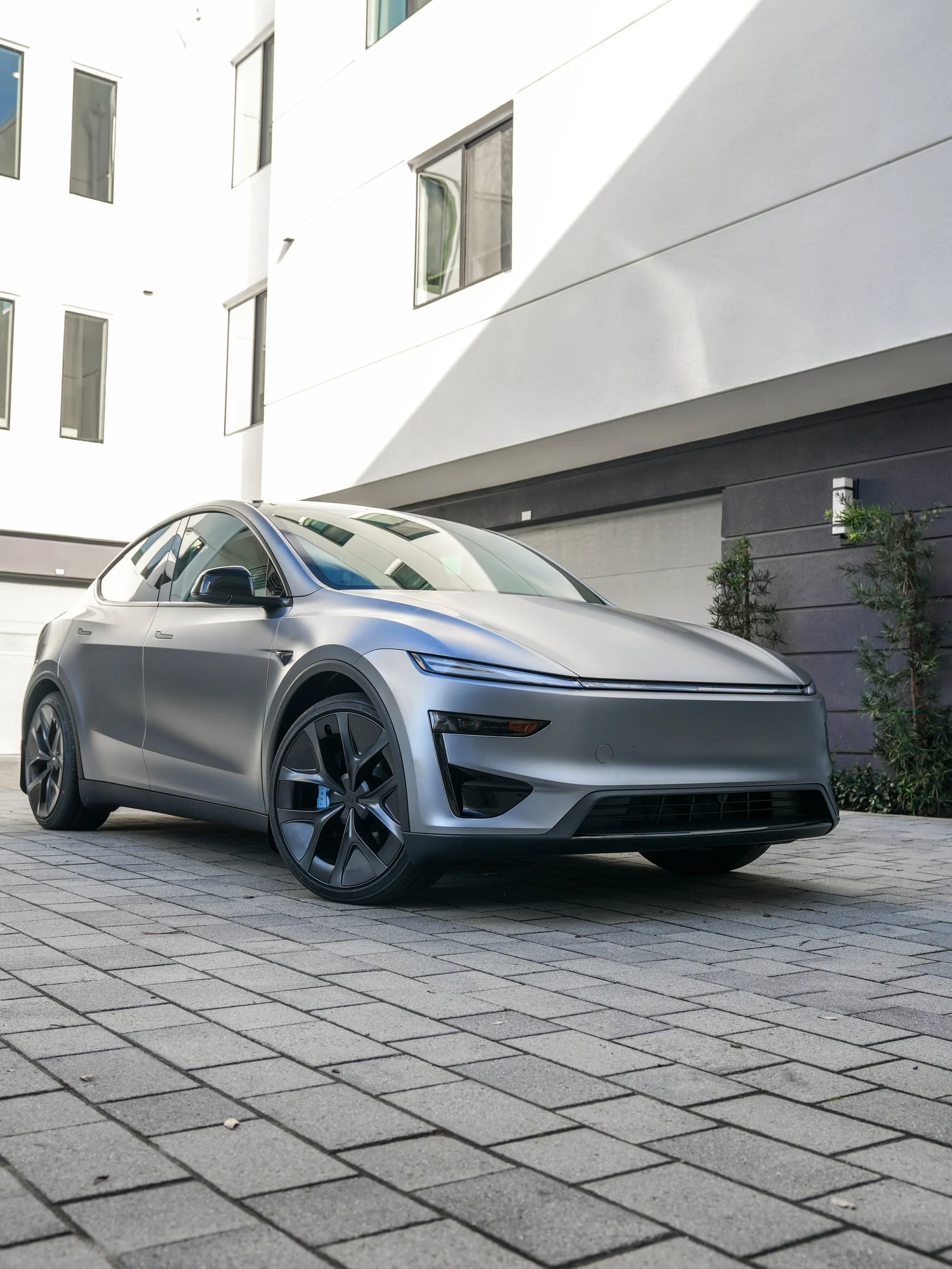 2026 Tesla Model Y Performance low front three-quarter view with baby blue front caliper after full XPEL STEALTH PPF and baby blue brake caliper repaint