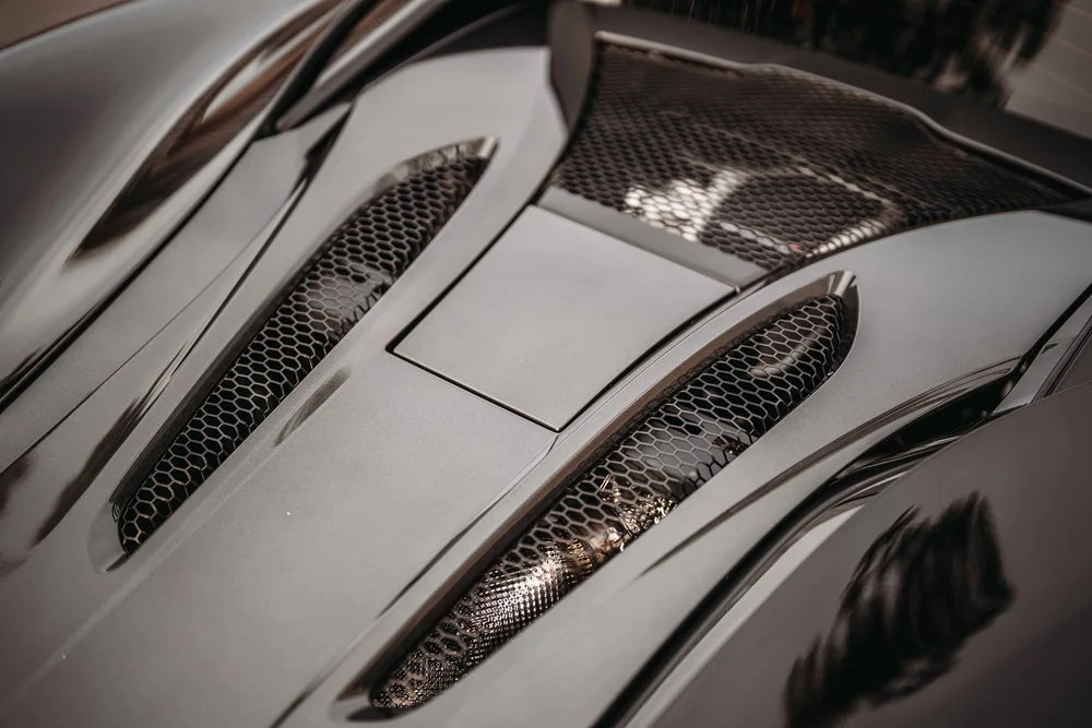 Angled close view of the rear deck's mesh vents and glossy sculpted panels.