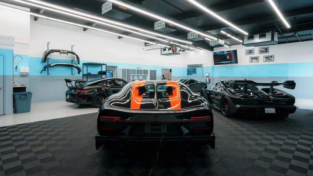 Inside the Toyz Detail Studio installation space with multiple performance vehicles