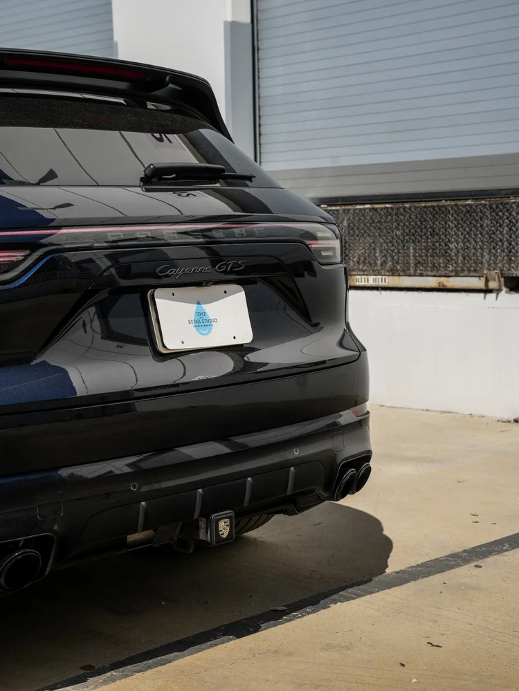 Close Porsche Cayenne GTS tailgate detail showing its Cayenne GTS badge, rear light strip, Toyz plate and part of the rear bumper.
