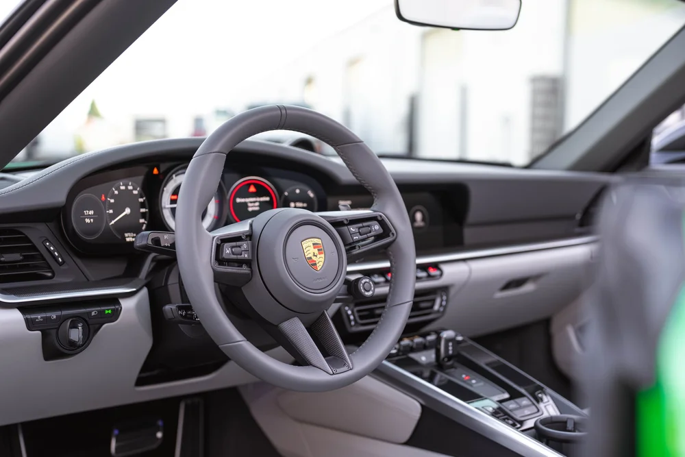 Signal Green Porsche 911 Turbo S, cockpit view of steering wheel, instruments, console and light interior