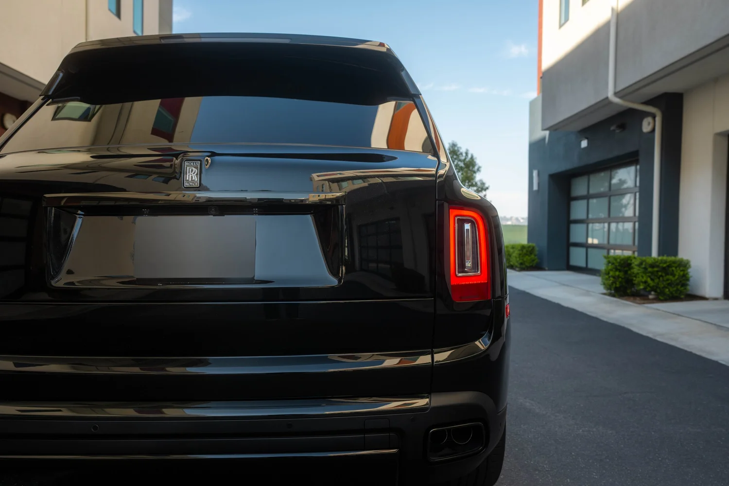 Black Rolls-Royce Cullinan Black Badge with Two-Tone Wheels after Paint Protection Film (PPF), Window Tint and Ceramic Coating, rear body and taillight view