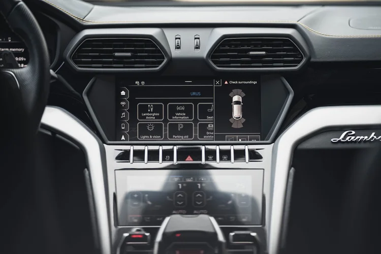 Center dashboard with two angular vents, stacked touchscreens and silver-colored trim around the console.