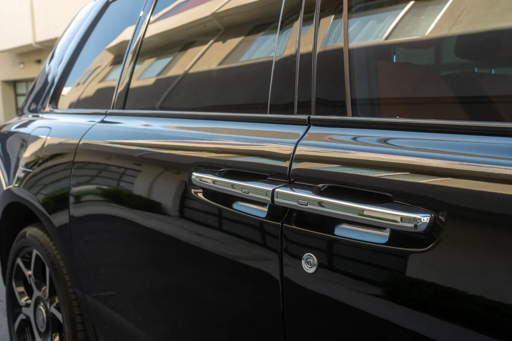 Black Rolls-Royce Cullinan Black Badge with Two-Tone Wheels — paired bright door handles, side glass and black door-panel finish