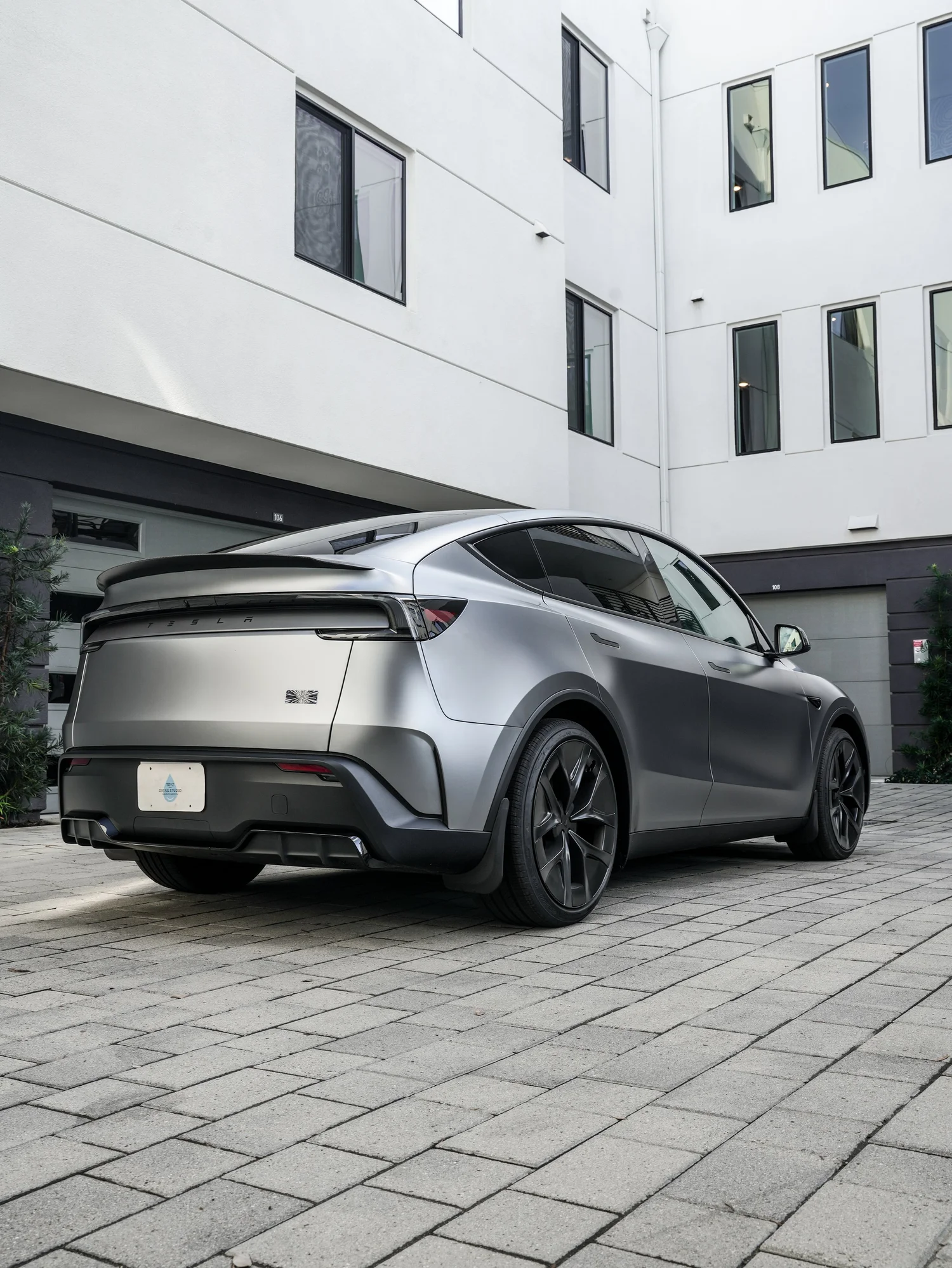 2026 Tesla Model Y Performance low rear three-quarter view after full XPEL STEALTH PPF and baby blue brake caliper repaint