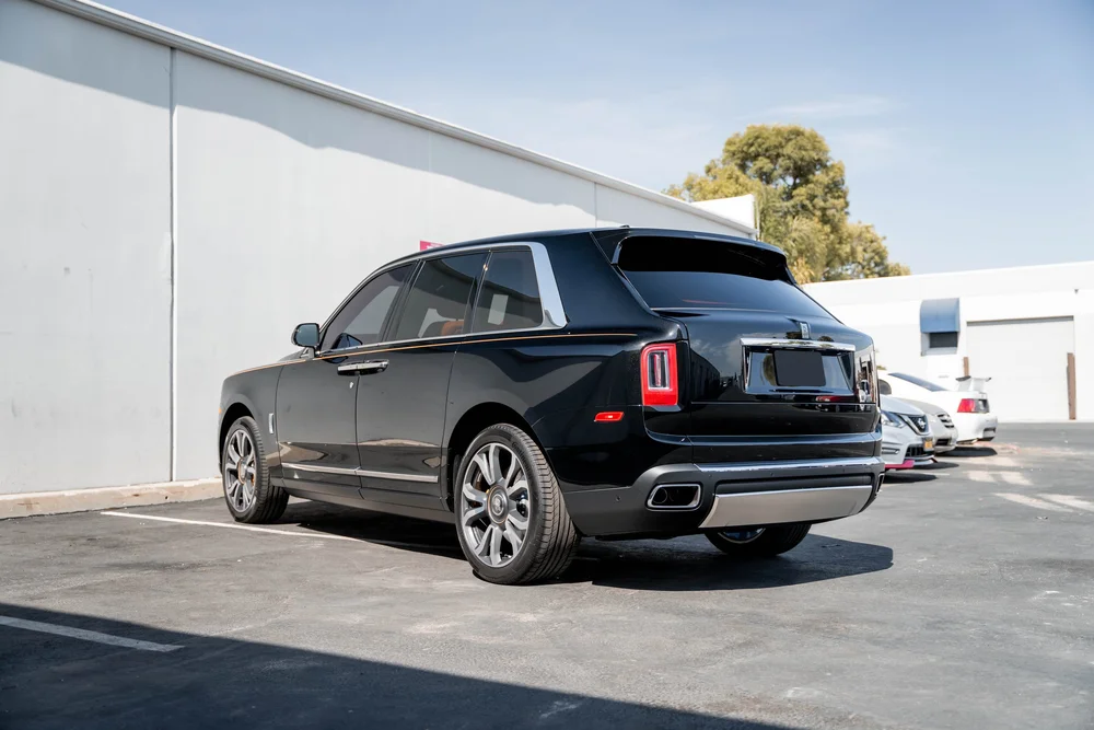 Black Rolls-Royce Cullinan with Chrome Exterior Trim — complete opposite rear three-quarter view showing the full SUV and bright exterior trim