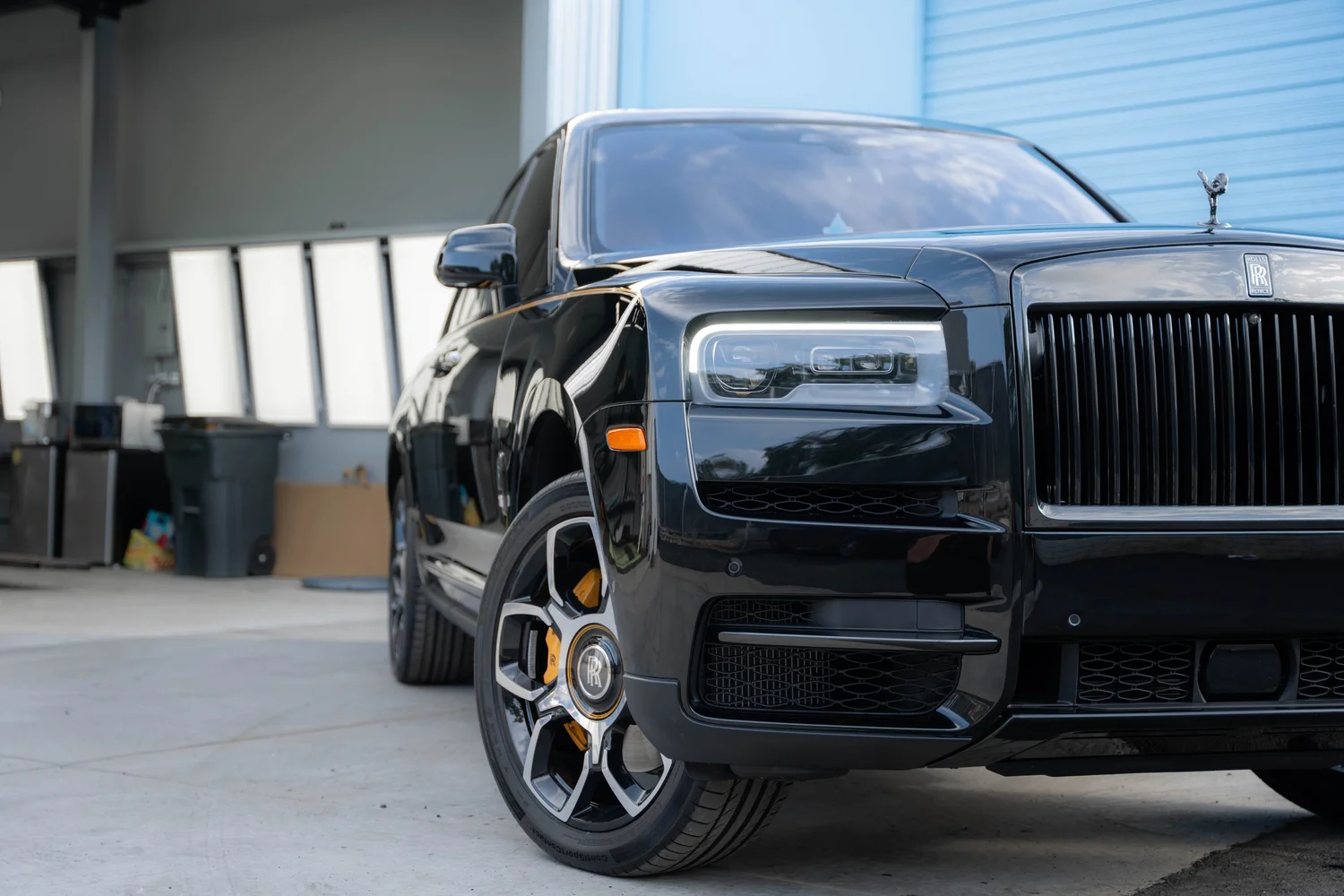 Black Rolls-Royce Cullinan Black Badge with Yellow Brake Calipers after Paint Protection Film (PPF), Window Tint and Ceramic Coating, front wheel and body view