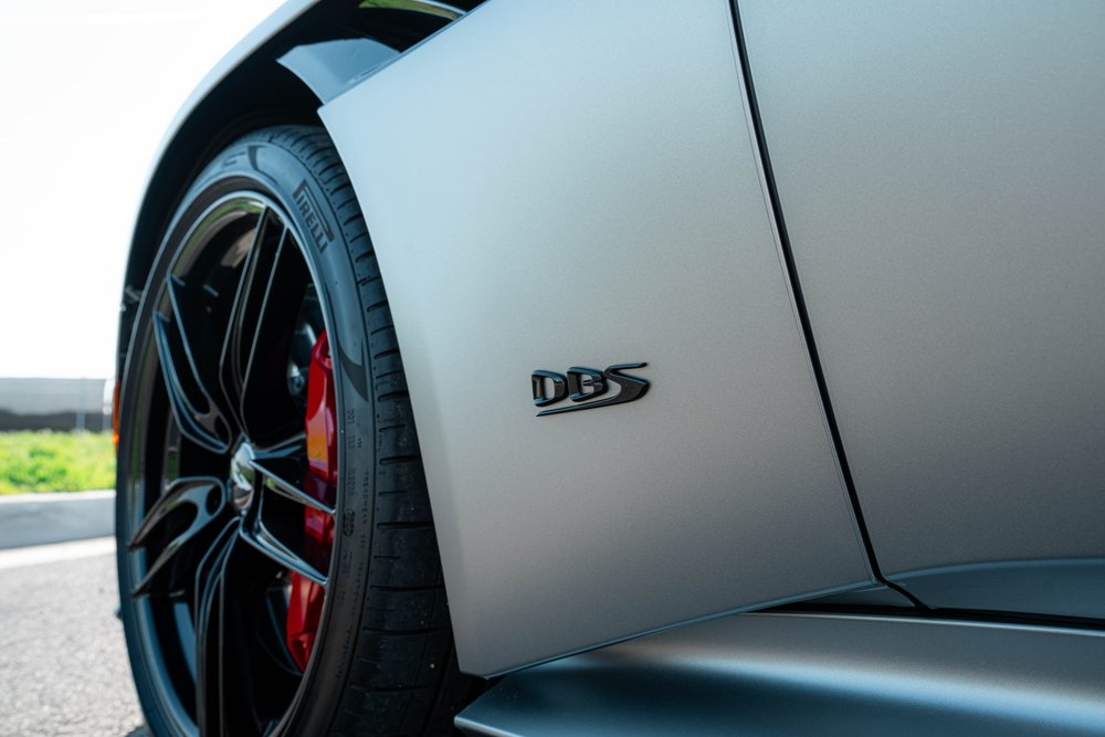 DBS badge on the matte side bodywork beside a black wheel and red brake caliper