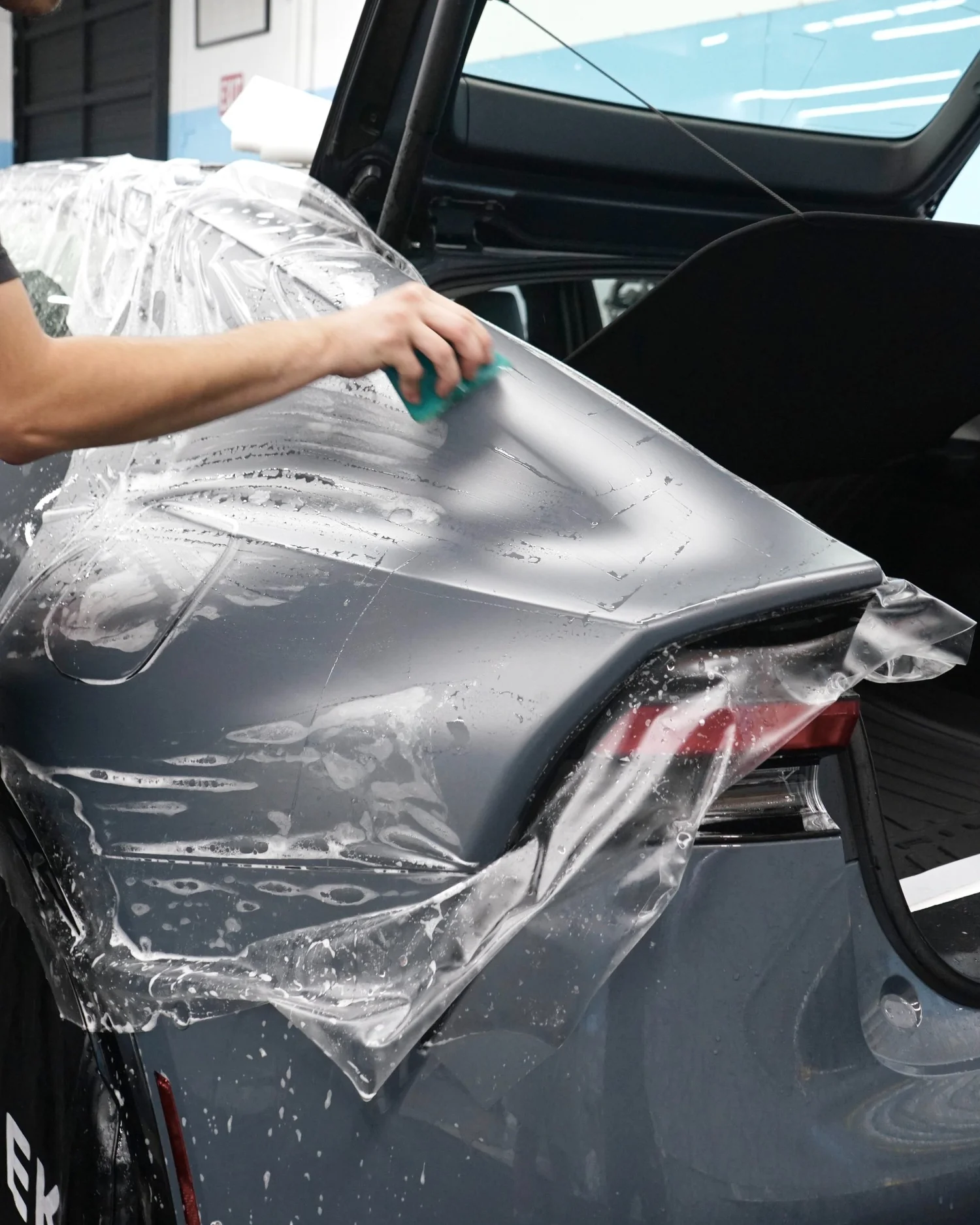 Paint protection film being prepared over a vehicle panel at Toyz Detail Studio