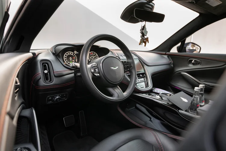Black cabin with steering wheel, dashboard and center console seen through the open door.