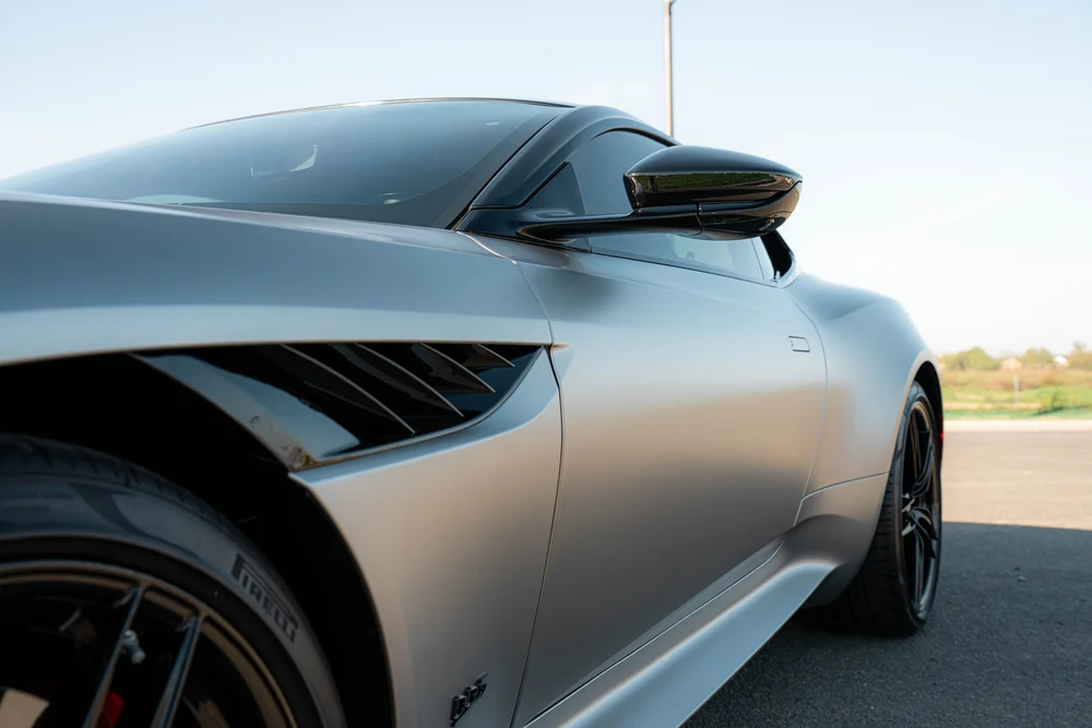 Aston Martin DBS side glass, dark mirror, side vent and matte door bodywork viewed from the front quarter