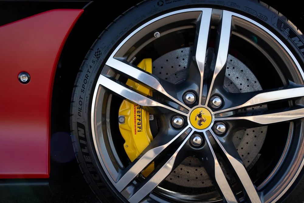 Ferrari Portofino two-tone wheel spokes, yellow brake caliper and drilled brake disc beside red bodywork
