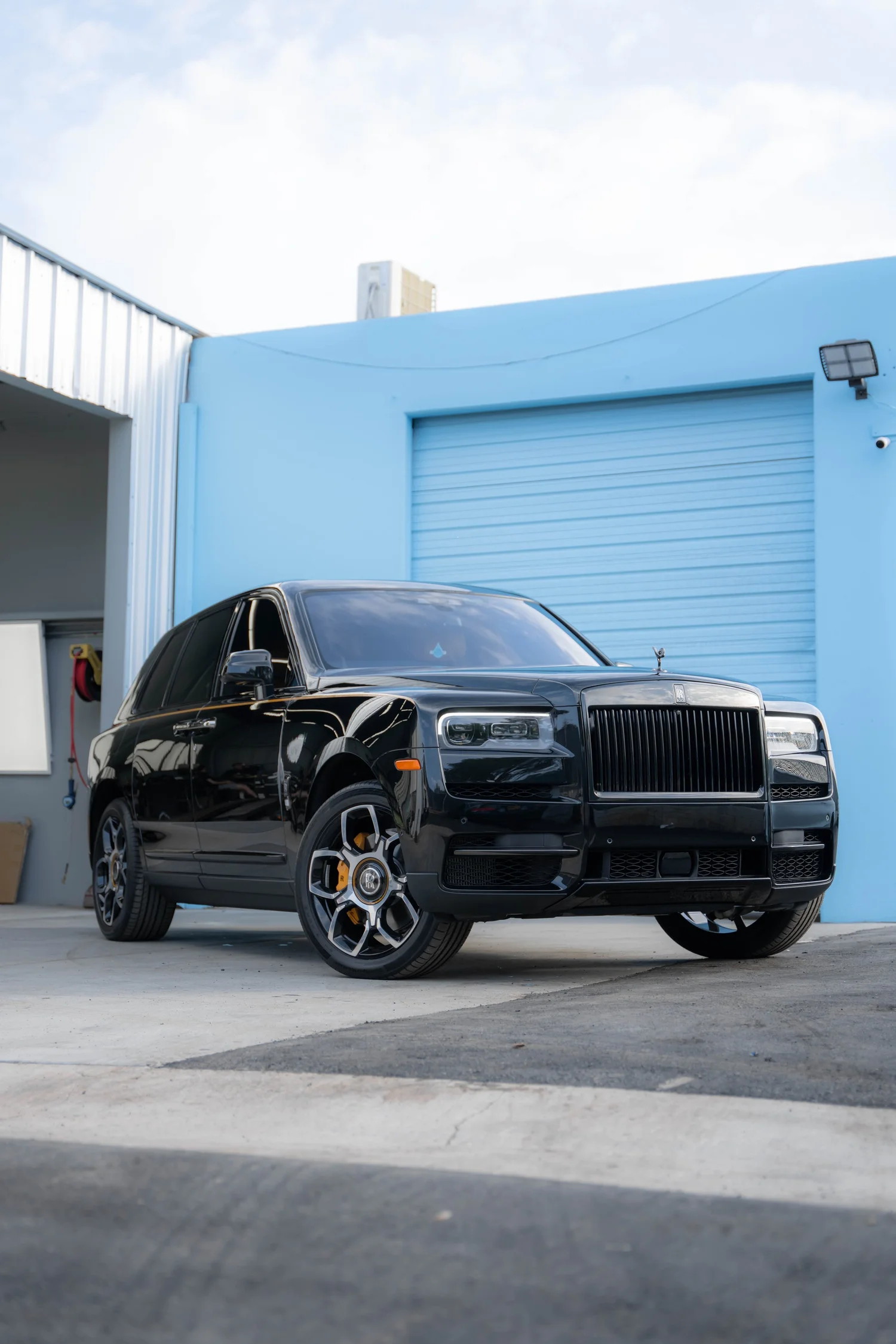 Black Rolls-Royce Cullinan Black Badge with Yellow Brake Calipers after Paint Protection Film (PPF), Window Tint and Ceramic Coating, low-angle front view