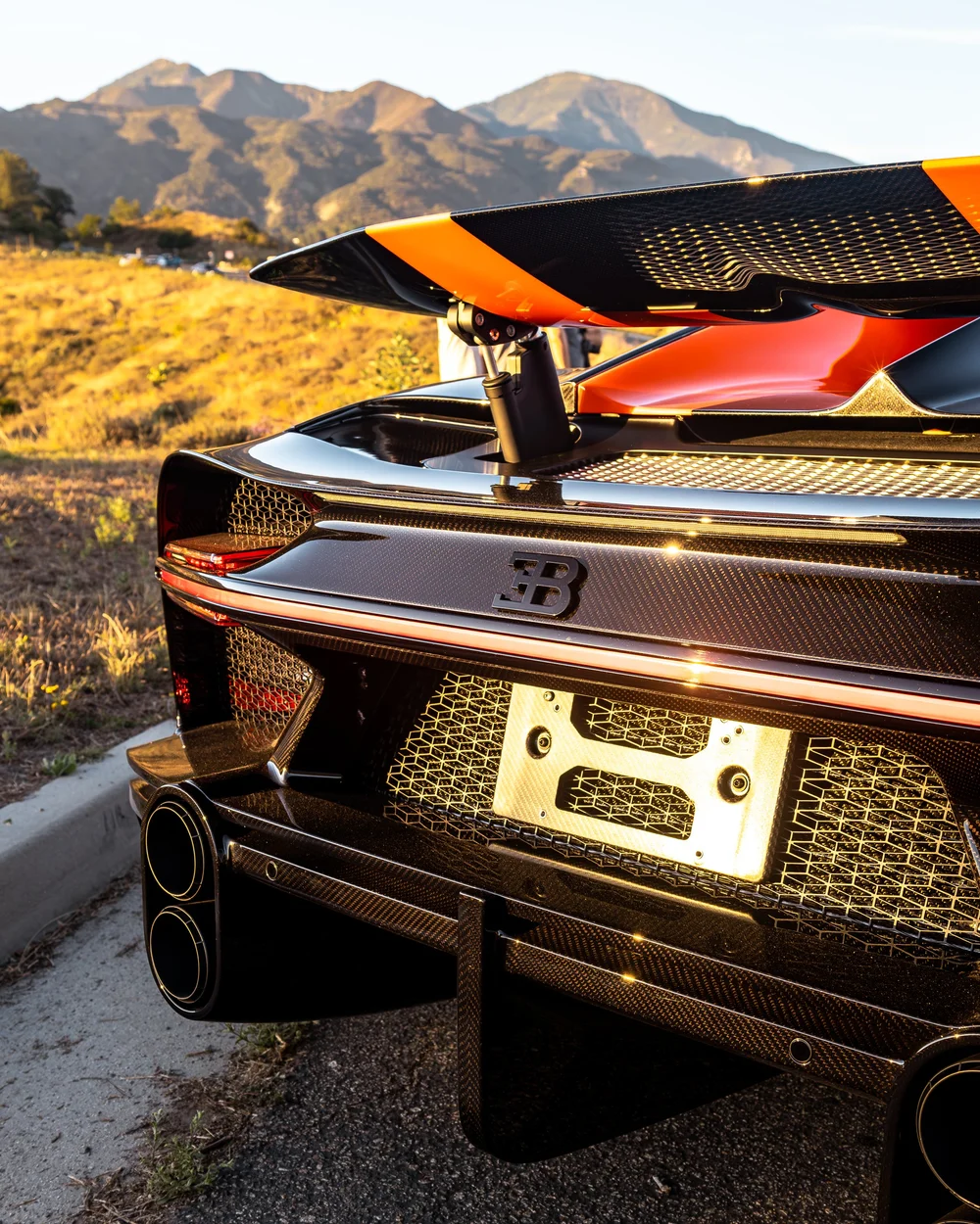 Rear close-up of the Bugatti Chiron Super Sport 300+ with raised wing, carbon fiber, and quad exhaust outlets