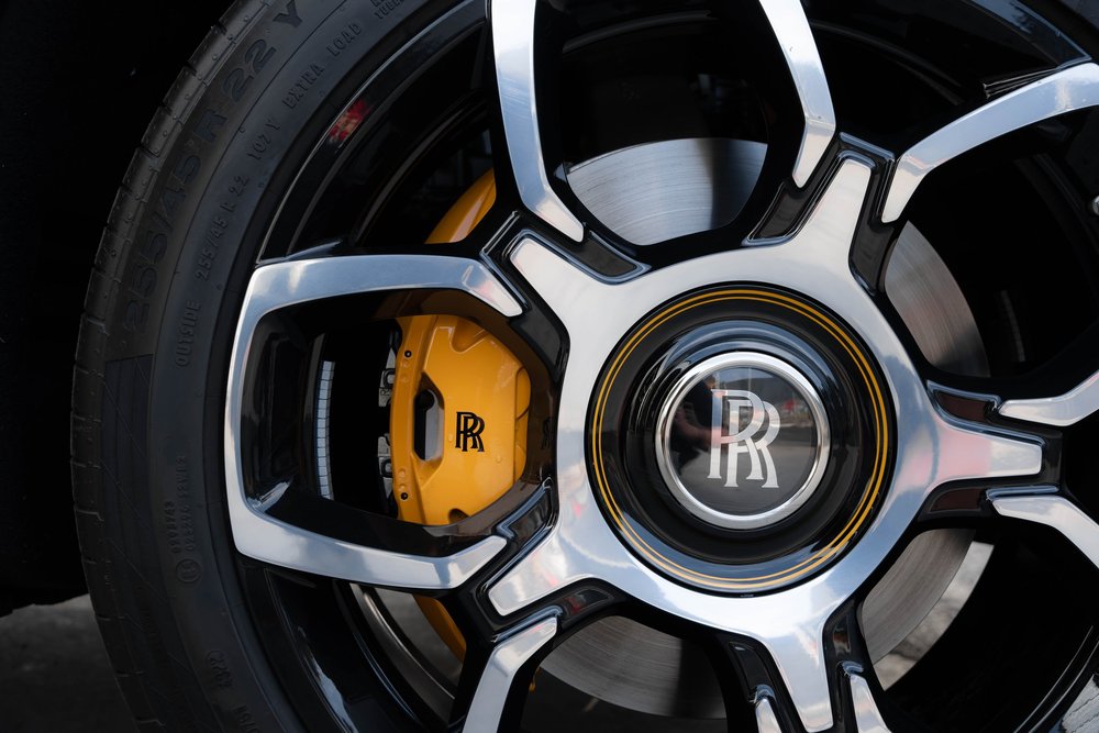 Yellow brake caliper behind a black-and-silver wheel with an RR center emblem.