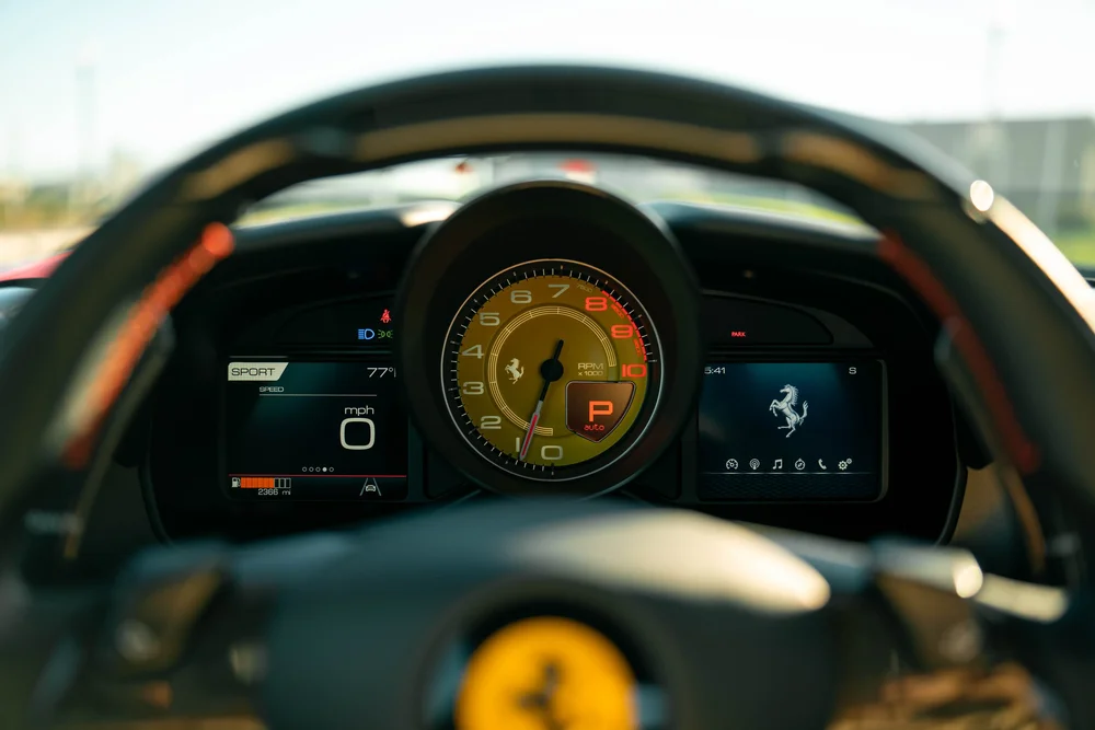 Ferrari F8 instrument cluster with yellow tachometer behind the steering wheel