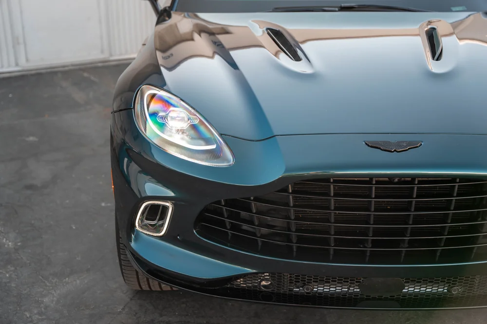 Close view of the sculpted hood vents, wing badge and illuminated headlamp.